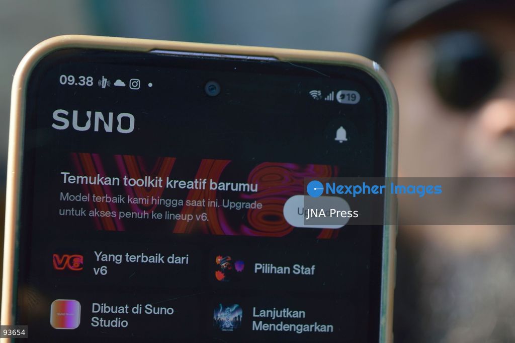 MEDAN, NORTH SUMATRA, INDONESIA, SEPTEMBER 17, 2026: The reflection of musician Jovan Siahaan, 42, appears on a smartphone displaying the Suno AI music platform as he arranges compositions for his digital solo project, Agent AI, in Medan, North Sumatra. Siahaan, who works as the project’s arranger and vocalist, uses artificial intelligence tools during the production process before adding his own vocal recordings to songs addressing social issues. The project is scheduled to perform at the Medanfor Thepunx #6 event. Photo by Sutanta Aditya / JNA Press. (Photo by Sutanta Aditya/JNA Press via Nexpher Images)