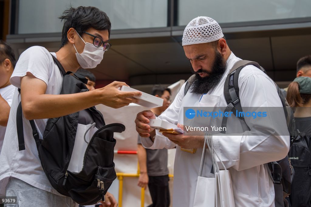 A reseller buying an iphone for a man outside an apple store on the first day on sale of the iphone 18 pro on September 18, 2026 in Hong Kong. (Photo by Vernon Yuen/Nexpher Images)