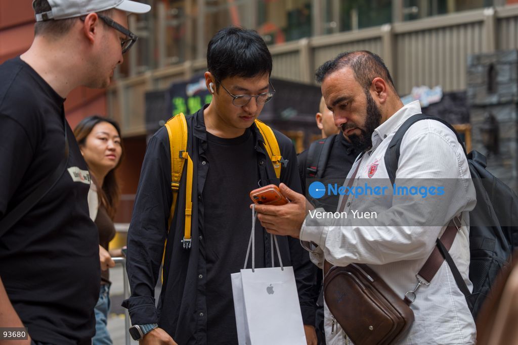 A reseller buying an iphone for a man outside an apple store on the first day on sale of the iphone 18 pro on September 18, 2026 in Hong Kong. (Photo by Vernon Yuen/Nexpher Images)