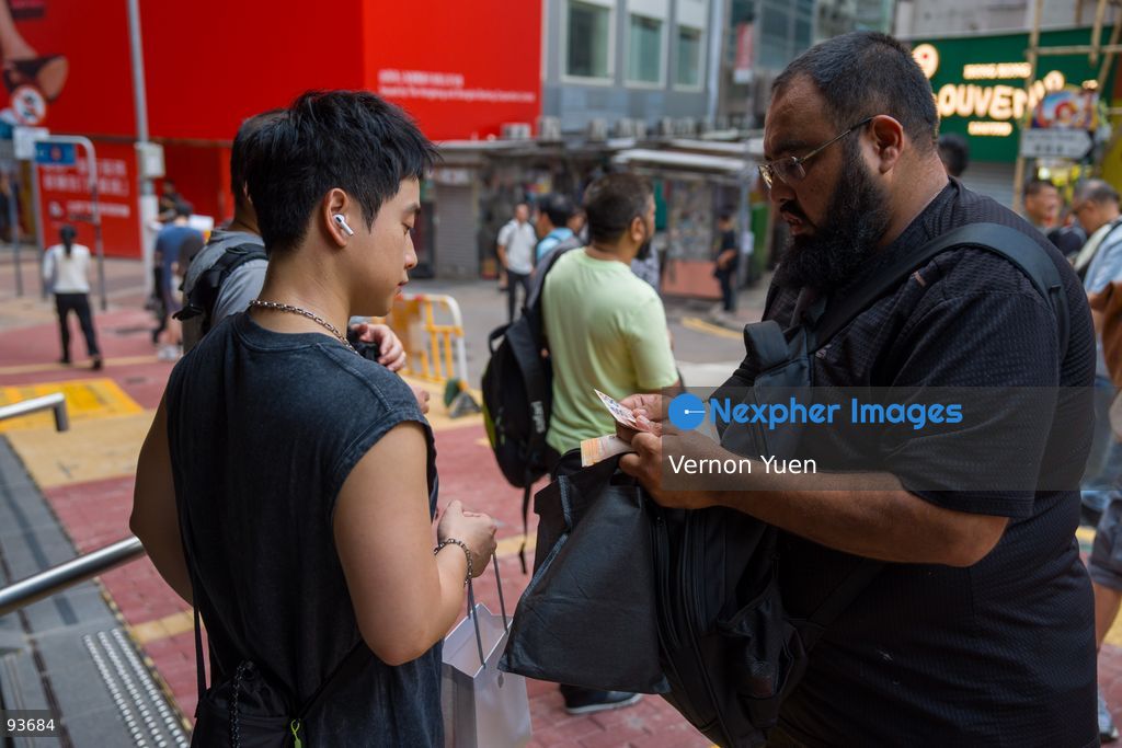 A reseller buying an iphone for a man outside an apple store on the first day on sale of the iphone 18 pro on September 18, 2026 in Hong Kong. (Photo by Vernon Yuen/Nexpher Images)