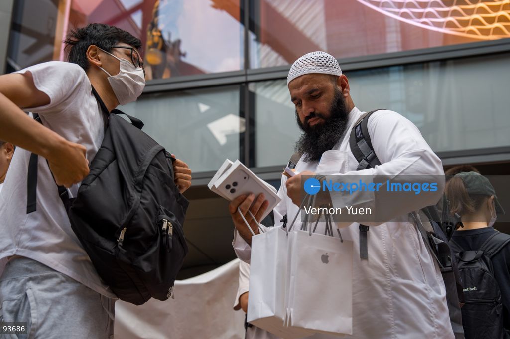 A reseller buying an iphone for a man outside an apple store on the first day on sale of the iphone 18 pro on September 18, 2026 in Hong Kong. (Photo by Vernon Yuen/Nexpher Images)