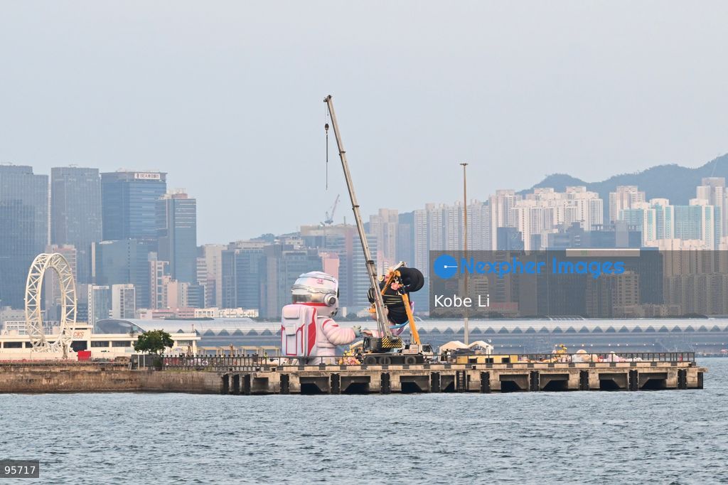 Construction workers working on a large cartoon character Hanfu and astronaut sculpture near the Victoria Harbour on September 22, 2026 in Hong Kong. (Photo by Kobe Li/Nexpher Images)