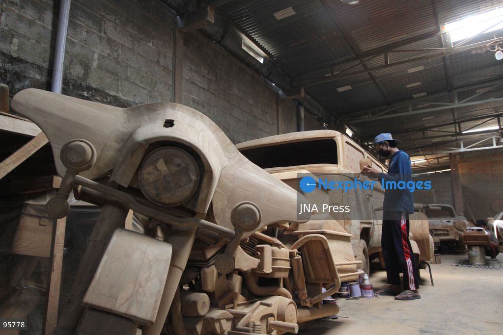 BOYOLALI, INDONESIA — SEPTEMBER 22, 2026: A worker applies a layer of varnish to a 1:1 scale wooden car and Harley-Davidson replica made from teak wood at Tetap Jaya Art Industrial House in Kemiri Village, Mojosongo District, Boyolali Regency, Central Java. The 1:1 scale vehicles take approximately one and a half months to complete, while smaller models take about two weeks. The products are ordered by buyers from several European countries at prices reaching tens of millions of rupiah. Mercedes-Benz, Renault, Ford, and Volkswagen cars, as well as Harley-Davidson and Vespa motorcycles, are among the customers' favorite models in European countries. Photo by Agung Mardika / JNA Press. (Photo by JNA EDITOR/JNA Press via Nexpher Images)