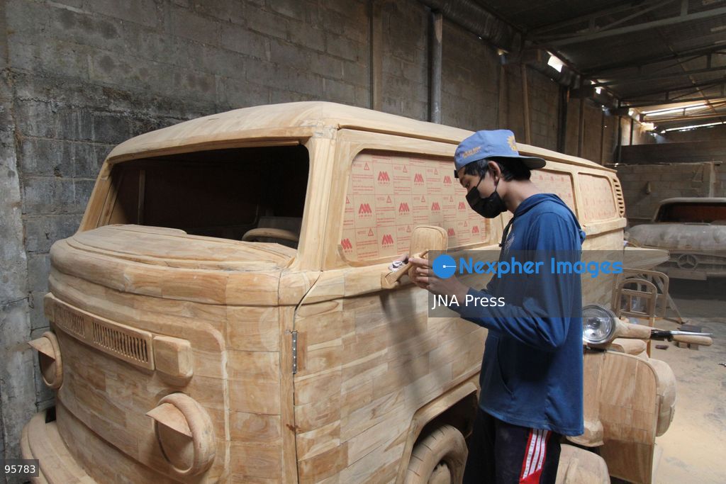 BOYOLALI, INDONESIA — SEPTEMBER 22, 2026: A worker applies a layer of varnish to a 1:1 scale wooden car and Harley-Davidson replica made from teak wood at Tetap Jaya Art Industrial House in Kemiri Village, Mojosongo District, Boyolali Regency, Central Java. The 1:1 scale vehicles take approximately one and a half months to complete, while smaller models take about two weeks. The products are ordered by buyers from several European countries at prices reaching tens of millions of rupiah. Mercedes-Benz, Renault, Ford, and Volkswagen cars, as well as Harley-Davidson and Vespa motorcycles, are among the customers' favorite models in European countries. Photo by Agung Mardika / JNA Press. (Photo by JNA EDITOR/JNA Press via Nexpher Images)