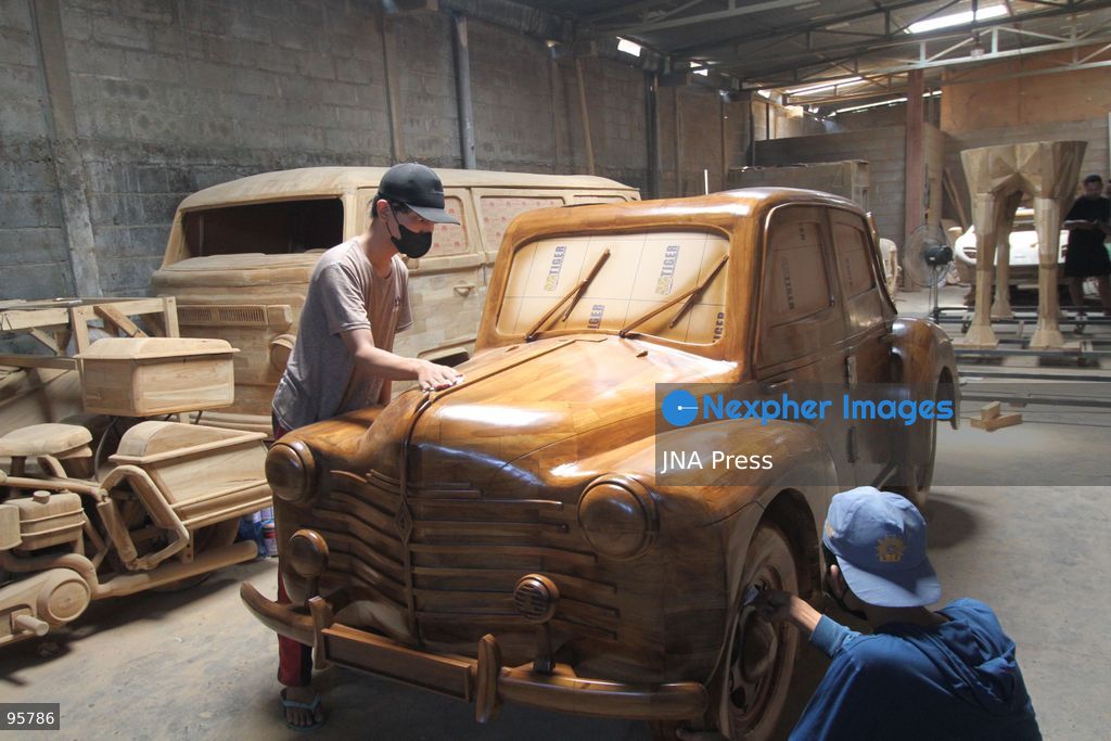 BOYOLALI, INDONESIA — SEPTEMBER 22, 2026: A worker applies a layer of varnish to a 1:1 scale wooden car and Harley-Davidson replica made from teak wood at Tetap Jaya Art Industrial House in Kemiri Village, Mojosongo District, Boyolali Regency, Central Java. The 1:1 scale vehicles take approximately one and a half months to complete, while smaller models take about two weeks. The products are ordered by buyers from several European countries at prices reaching tens of millions of rupiah. Mercedes-Benz, Renault, Ford, and Volkswagen cars, as well as Harley-Davidson and Vespa motorcycles, are among the customers' favorite models in European countries. Photo by Agung Mardika / JNA Press. (Photo by JNA EDITOR/JNA Press via Nexpher Images)