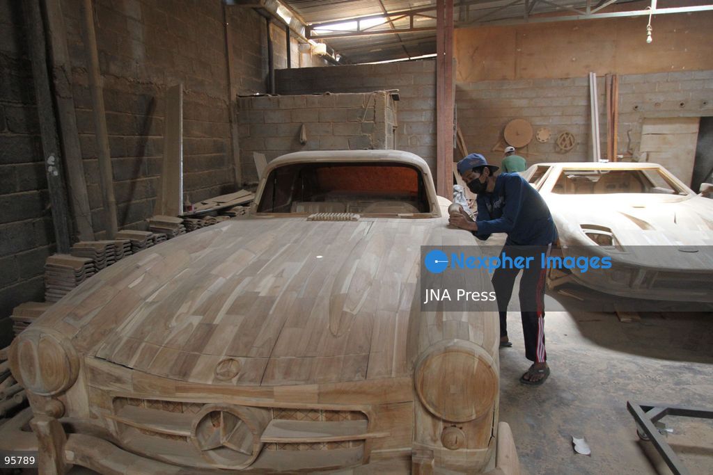 BOYOLALI, INDONESIA — SEPTEMBER 22, 2026: A worker applies a layer of varnish to a 1:1 scale wooden car and Harley-Davidson replica made from teak wood at Tetap Jaya Art Industrial House in Kemiri Village, Mojosongo District, Boyolali Regency, Central Java. The 1:1 scale vehicles take approximately one and a half months to complete, while smaller models take about two weeks. The products are ordered by buyers from several European countries at prices reaching tens of millions of rupiah. Mercedes-Benz, Renault, Ford, and Volkswagen cars, as well as Harley-Davidson and Vespa motorcycles, are among the customers' favorite models in European countries. Photo by Agung Mardika / JNA Press. (Photo by JNA EDITOR/JNA Press via Nexpher Images)