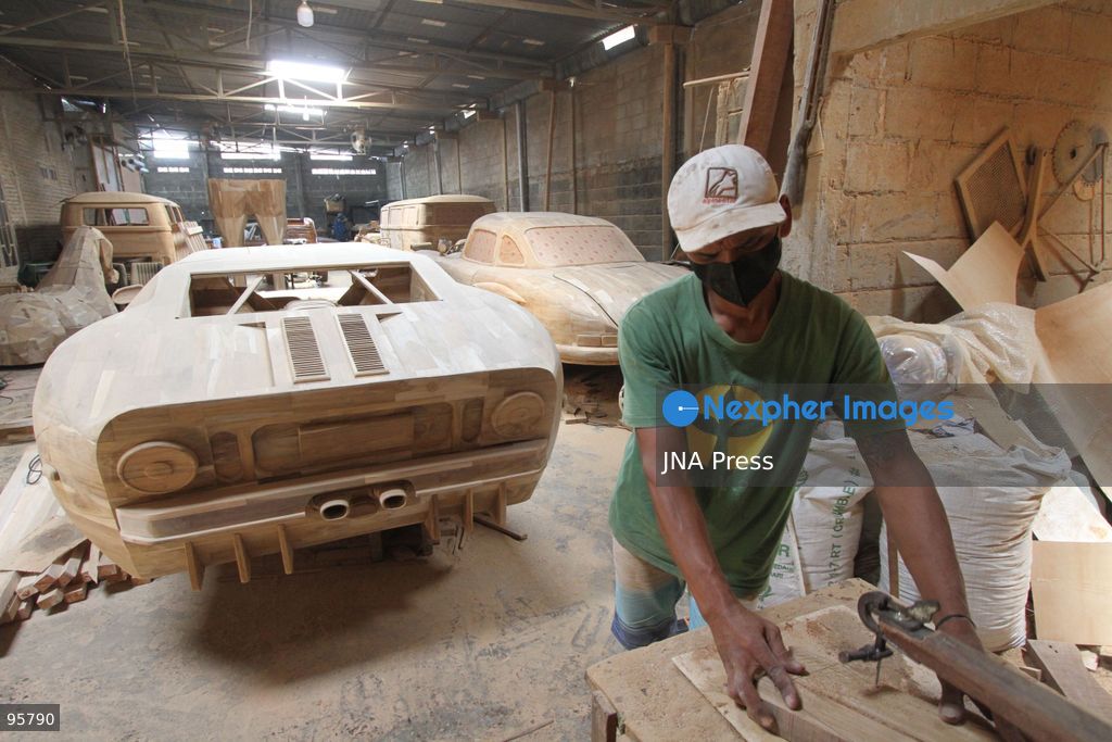 BOYOLALI, INDONESIA — SEPTEMBER 22, 2026: A worker applies a layer of varnish to a 1:1 scale wooden car and Harley-Davidson replica made from teak wood at Tetap Jaya Art Industrial House in Kemiri Village, Mojosongo District, Boyolali Regency, Central Java. The 1:1 scale vehicles take approximately one and a half months to complete, while smaller models take about two weeks. The products are ordered by buyers from several European countries at prices reaching tens of millions of rupiah. Mercedes-Benz, Renault, Ford, and Volkswagen cars, as well as Harley-Davidson and Vespa motorcycles, are among the customers' favorite models in European countries. Photo by Agung Mardika / JNA Press. (Photo by JNA EDITOR/JNA Press via Nexpher Images)