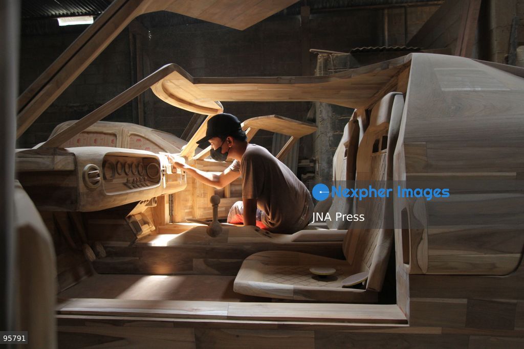 BOYOLALI, INDONESIA — SEPTEMBER 22, 2026: A worker applies a layer of varnish to a 1:1 scale wooden car and Harley-Davidson replica made from teak wood at Tetap Jaya Art Industrial House in Kemiri Village, Mojosongo District, Boyolali Regency, Central Java. The 1:1 scale vehicles take approximately one and a half months to complete, while smaller models take about two weeks. The products are ordered by buyers from several European countries at prices reaching tens of millions of rupiah. Mercedes-Benz, Renault, Ford, and Volkswagen cars, as well as Harley-Davidson and Vespa motorcycles, are among the customers' favorite models in European countries. Photo by Agung Mardika / JNA Press. (Photo by JNA EDITOR/JNA Press via Nexpher Images)