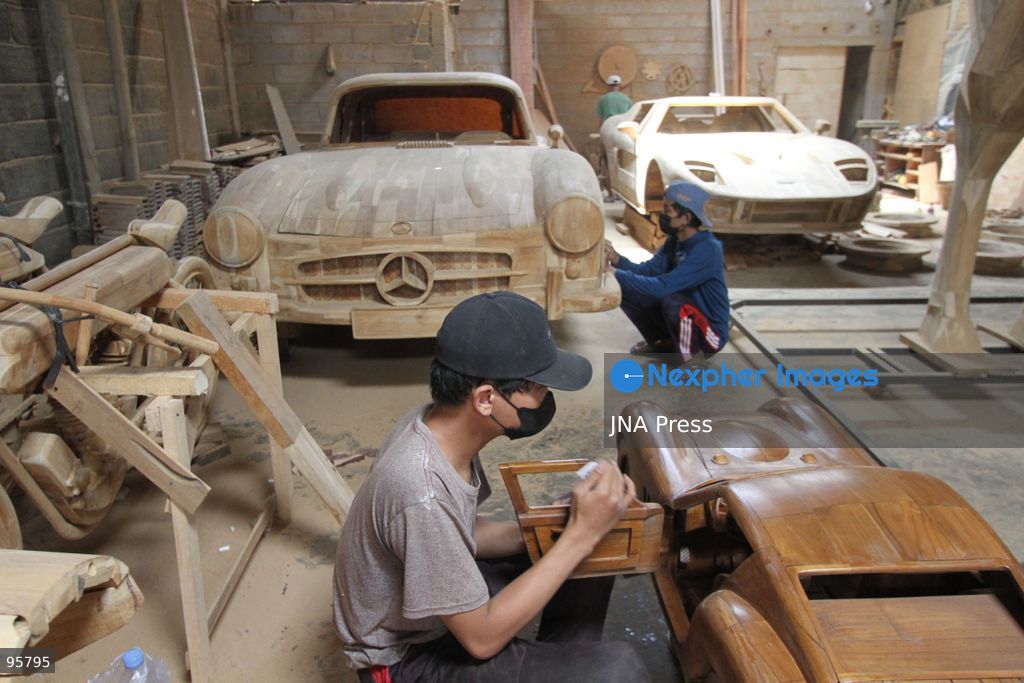 BOYOLALI, INDONESIA — SEPTEMBER 22, 2026: A worker applies a layer of varnish to a 1:1 scale wooden car and Harley-Davidson replica made from teak wood at Tetap Jaya Art Industrial House in Kemiri Village, Mojosongo District, Boyolali Regency, Central Java. The 1:1 scale vehicles take approximately one and a half months to complete, while smaller models take about two weeks. The products are ordered by buyers from several European countries at prices reaching tens of millions of rupiah. Mercedes-Benz, Renault, Ford, and Volkswagen cars, as well as Harley-Davidson and Vespa motorcycles, are among the customers' favorite models in European countries. Photo by Agung Mardika / JNA Press. (Photo by JNA EDITOR/JNA Press via Nexpher Images)
