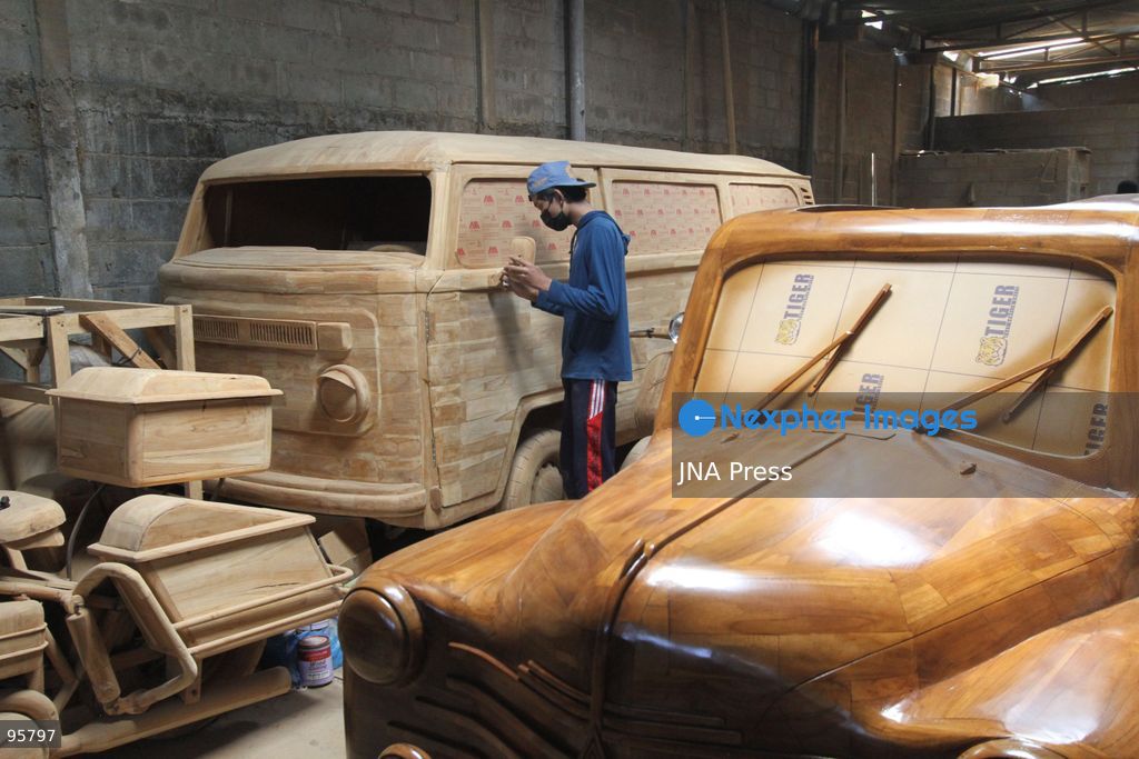 BOYOLALI, INDONESIA — SEPTEMBER 22, 2026: A worker applies a layer of varnish to a 1:1 scale wooden car and Harley-Davidson replica made from teak wood at Tetap Jaya Art Industrial House in Kemiri Village, Mojosongo District, Boyolali Regency, Central Java. The 1:1 scale vehicles take approximately one and a half months to complete, while smaller models take about two weeks. The products are ordered by buyers from several European countries at prices reaching tens of millions of rupiah. Mercedes-Benz, Renault, Ford, and Volkswagen cars, as well as Harley-Davidson and Vespa motorcycles, are among the customers' favorite models in European countries. Photo by Agung Mardika / JNA Press. (Photo by JNA EDITOR/JNA Press via Nexpher Images)