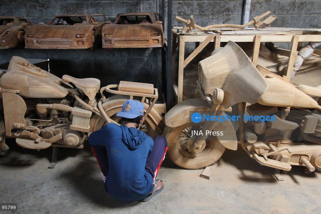 BOYOLALI, INDONESIA — SEPTEMBER 22, 2026: A worker applies a layer of varnish to a 1:1 scale wooden car and Harley-Davidson replica made from teak wood at Tetap Jaya Art Industrial House in Kemiri Village, Mojosongo District, Boyolali Regency, Central Java. The 1:1 scale vehicles take approximately one and a half months to complete, while smaller models take about two weeks. The products are ordered by buyers from several European countries at prices reaching tens of millions of rupiah. Mercedes-Benz, Renault, Ford, and Volkswagen cars, as well as Harley-Davidson and Vespa motorcycles, are among the customers' favorite models in European countries. Photo by Agung Mardika / JNA Press. (Photo by JNA EDITOR/JNA Press via Nexpher Images)