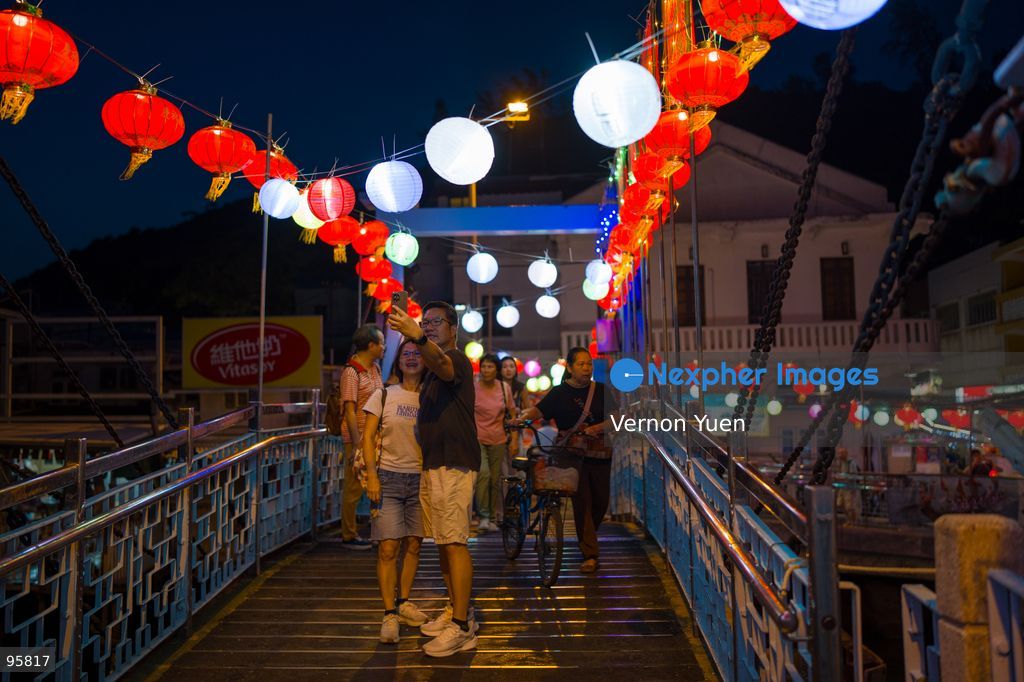 People talking photos on a bridge with lanterns handing on it at Shek O on September 23, 2026 in Hong Kong. (Photo by Vernon Yuen/Nexpher Images)