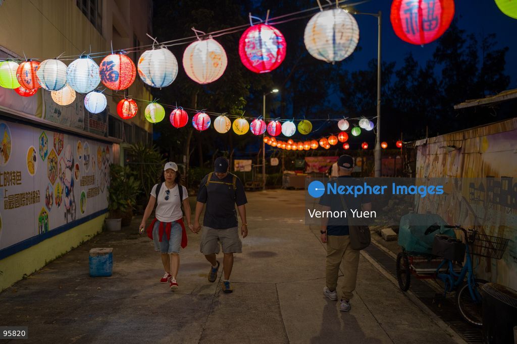 People walking pass lanterns hanging over head at Shek O on September 23, 2026 in Hong Kong. (Photo by Vernon Yuen/Nexpher Images)