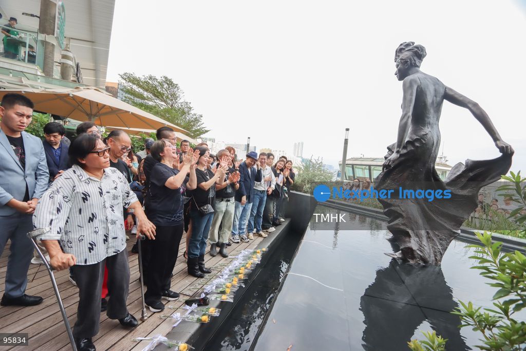 Members of the fan club "Mui Nation", accompanied by veteran radio host Candy Chea Shuk-mui, former broadcasting executive Cheung Man-sun, filmmaker Manfred Wong, and veteran actress Susan Shaw Yin-yin, view details of the newly restored bronze statue of the late pop diva Anita Mui at the Avenue of Stars on September 22, 2026 in Hong Kong. (Photo by Gordon Choi/TMHK via Nexpher Images)