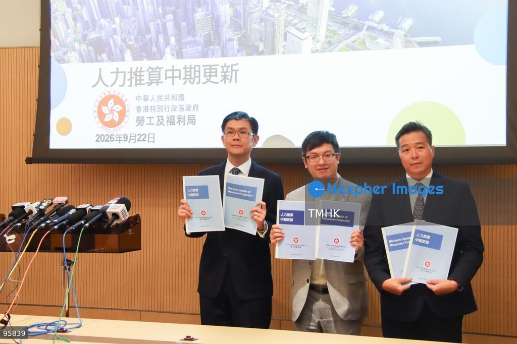 Acting Secretary for Labour and Welfare Ho Kai-ming, Deputy Secretary for Labour and Welfare (Manpower) Andrew Tsang, and Head (Research Unit) Roy Chan hold hard copies of the mid-term update of the "Report on Manpower Projection" during a photo call before a media briefing at the Central Government Offices on September 22, 2026 in Hong Kong. The update projects the city's manpower shortage to narrow to approximately 130,000 by 2028, driven by the adoption of artificial intelligence and various talent admission schemes, while highlighting shifts in entry-level and clerical employment. (Photo by Gordon Choi/TMHK via Nexpher Images)