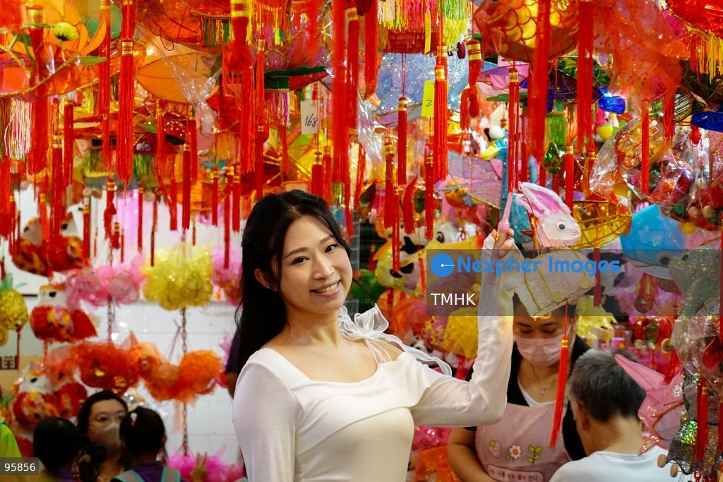A young woman poses for a photograph with a traditional lantern amidst a festive backdrop of paper and plastic lanterns inside an old shop on September 22, 2026 in Hong Kong, soaking in the nostalgic atmosphere ahead of the Mid-Autumn Festival. (Photo by Zulu Lo/TMHK via Nexpher Images)