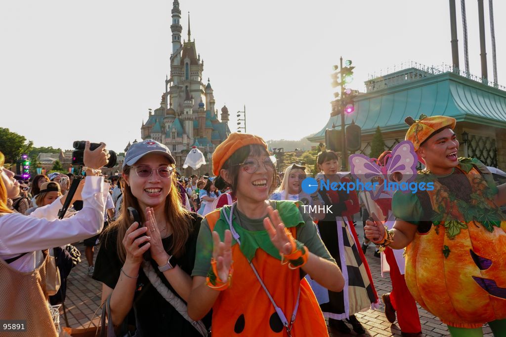 Visitors dressed in creative pumpkin-themed costumes take photographs and take part in seasonal celebrations in front of the Castle of Magical Dreams during "Disney Halloween Time" at Hong Kong Disneyland on September 20, 2026 in Hong Kong. (Photo by Zulu Lo/TMHK via Nexpher Images)
