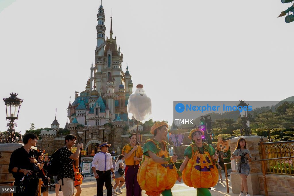 Visitors dressed in creative pumpkin-themed costumes take photographs and take part in seasonal celebrations in front of the Castle of Magical Dreams during "Disney Halloween Time" at Hong Kong Disneyland on September 20, 2026 in Hong Kong. (Photo by Zulu Lo/TMHK via Nexpher Images)