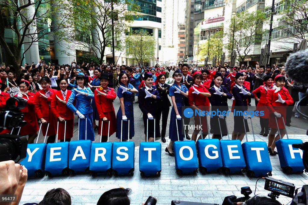 A general view shows cabin crew and ground staff wearing vintage and current uniforms performing alongside professional dancers during Cathay Pacific's 80th anniversary dance performance at Taikoo Place in Quarry Bay on September 24, 2026 in Hong Kong. Choreographed by the Hong Kong Dance Company, the flash mob-style showcase celebrated the airline's eight decades of journey alongside the city. (Photo by Zulu Lo/TMHK via Nexpher Images)