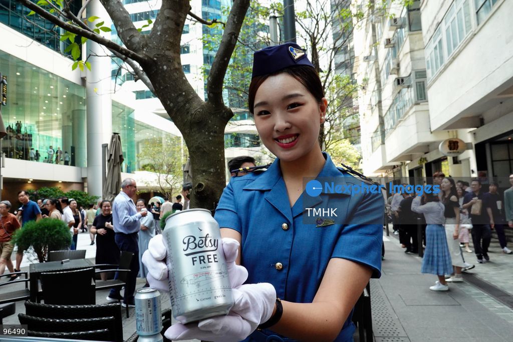 Cathay Pacific staff members and cabin crew distribute cans of the airline's signature "Betsy Beer" to members of the public during the carrier's 80th anniversary celebration at Taikoo Place on September 24, 2026 in Hong Kong. (Photo by Zulu Lo/TMHK via Nexpher Images)