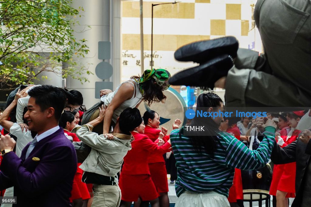 A general view shows cabin crew and ground staff wearing vintage and current uniforms performing alongside professional dancers during Cathay Pacific's 80th anniversary dance performance at Taikoo Place in Quarry Bay on September 24, 2026 in Hong Kong. Choreographed by the Hong Kong Dance Company, the flash mob-style showcase celebrated the airline's eight decades of journey alongside the city. (Photo by Zulu Lo/TMHK via Nexpher Images)