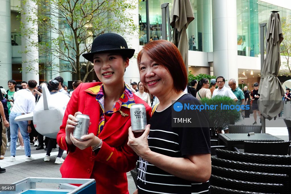 A close-up view shows a Cathay Pacific staff member handing a can of "Betsy Beer" to a spectator during the airline's 80th anniversary showcase on September 24, 2026 in Hong Kong. (Photo by Zulu Lo/TMHK via Nexpher Images)