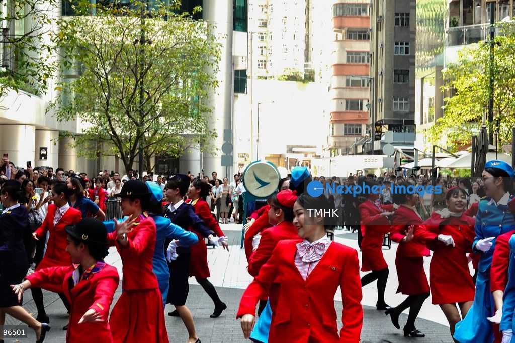 A general view shows cabin crew and ground staff wearing vintage and current uniforms performing alongside professional dancers during Cathay Pacific's 80th anniversary dance performance at Taikoo Place in Quarry Bay on September 24, 2026 in Hong Kong. Choreographed by the Hong Kong Dance Company, the flash mob-style showcase celebrated the airline's eight decades of journey alongside the city. (Photo by Zulu Lo/TMHK via Nexpher Images)