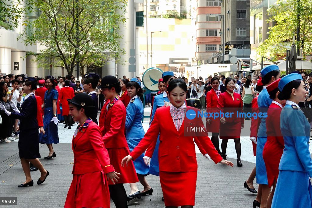 A general view shows cabin crew and ground staff wearing vintage and current uniforms performing alongside professional dancers during Cathay Pacific's 80th anniversary dance performance at Taikoo Place in Quarry Bay on September 24, 2026 in Hong Kong. Choreographed by the Hong Kong Dance Company, the flash mob-style showcase celebrated the airline's eight decades of journey alongside the city. (Photo by Zulu Lo/TMHK via Nexpher Images)