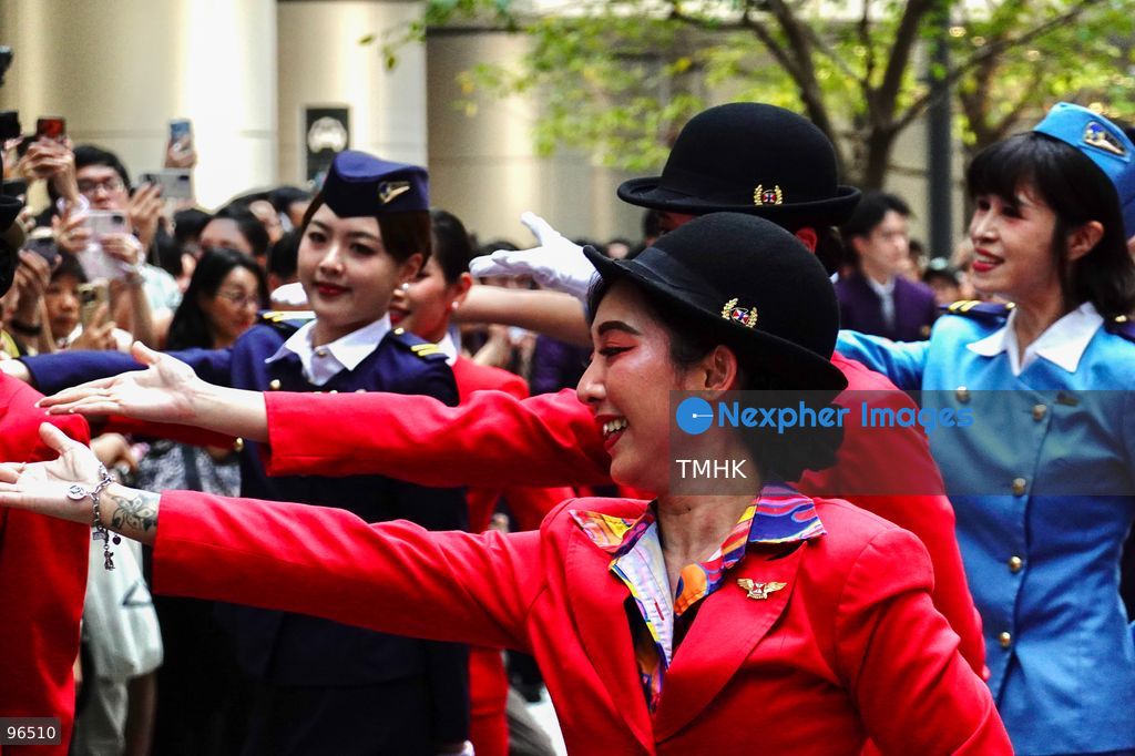 A general view shows cabin crew and ground staff wearing vintage and current uniforms performing alongside professional dancers during Cathay Pacific's 80th anniversary dance performance at Taikoo Place in Quarry Bay on September 24, 2026 in Hong Kong. Choreographed by the Hong Kong Dance Company, the flash mob-style showcase celebrated the airline's eight decades of journey alongside the city. (Photo by Zulu Lo/TMHK via Nexpher Images)