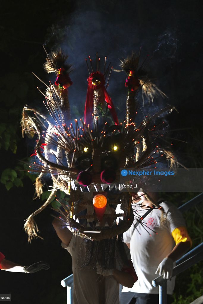 A man holding up the head of a Fire Dragon into the sea during a fire dragon dance performance in Wah Fu Estate at Mid-autumn Festival on September 25, 2026 in Hong Kong. (Photo by Kobe Li/Nexpher Images)