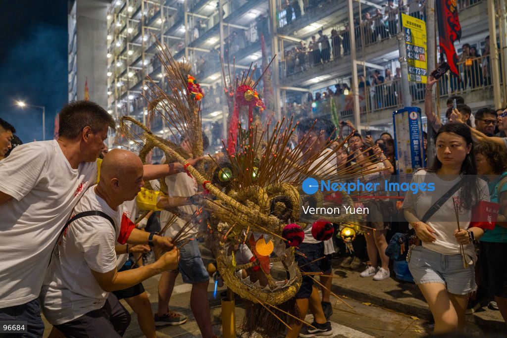 Performers sticking incense sticks onto a fire dragon at Wah Fu Estate on September 25, 2026 in Hong Kong. (Photo by Vernon Yuen/Nexpher Images)
