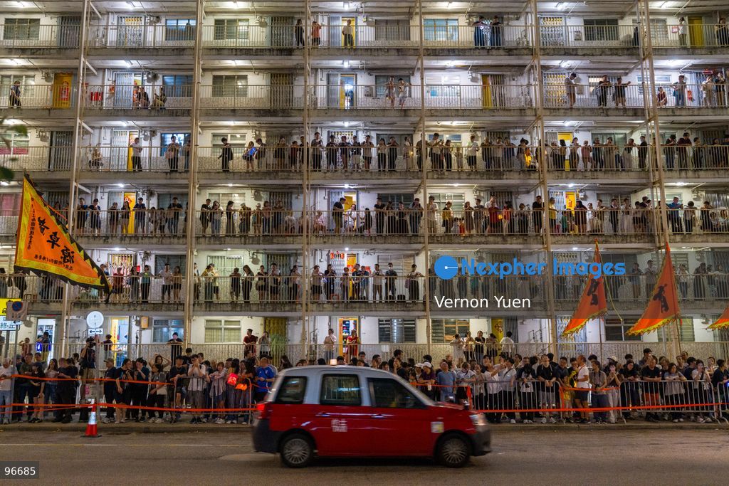 People standing on the side of the road and on the balconies of Wah Fu Estate, a public housing estate to view a fire dragon dance performance on September 25, 2026 in Hong Kong. (Photo by Vernon Yuen/Nexpher Images)
