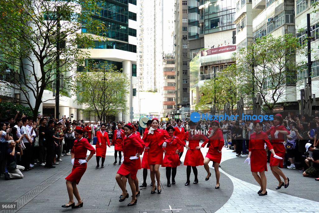 A general view shows cabin crew and ground staff wearing vintage and current uniforms performing alongside professional dancers during Cathay Pacific's 80th anniversary dance performance at Taikoo Place in Quarry Bay on September 24, 2026 in Hong Kong. Choreographed by the Hong Kong Dance Company, the flash mob-style showcase celebrated the airline's eight decades of journey alongside the city. (Photo by Zulu Lo/TMHK via Nexpher Images)