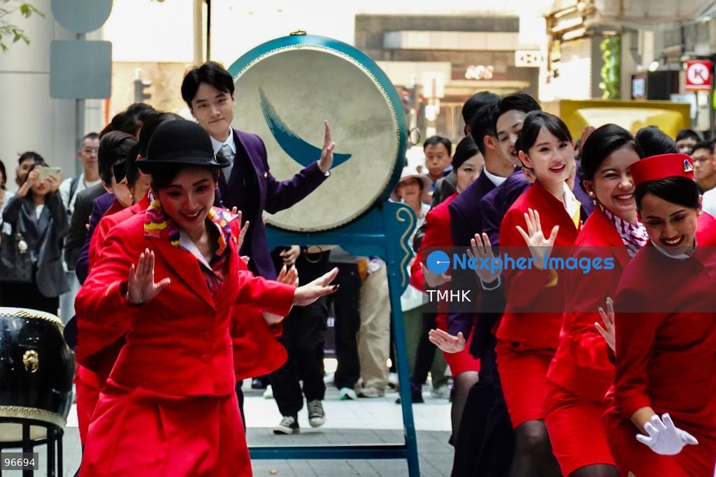 A general view shows cabin crew and ground staff wearing vintage and current uniforms performing alongside professional dancers during Cathay Pacific's 80th anniversary dance performance at Taikoo Place in Quarry Bay on September 24, 2026 in Hong Kong. Choreographed by the Hong Kong Dance Company, the flash mob-style showcase celebrated the airline's eight decades of journey alongside the city. (Photo by Zulu Lo/TMHK via Nexpher Images)