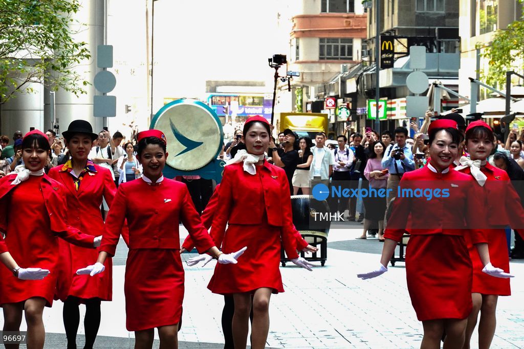 A general view shows cabin crew and ground staff wearing vintage and current uniforms performing alongside professional dancers during Cathay Pacific's 80th anniversary dance performance at Taikoo Place in Quarry Bay on September 24, 2026 in Hong Kong. Choreographed by the Hong Kong Dance Company, the flash mob-style showcase celebrated the airline's eight decades of journey alongside the city. (Photo by Zulu Lo/TMHK via Nexpher Images)