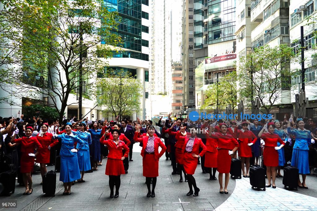 A general view shows cabin crew and ground staff wearing vintage and current uniforms performing alongside professional dancers during Cathay Pacific's 80th anniversary dance performance at Taikoo Place in Quarry Bay on September 24, 2026 in Hong Kong. Choreographed by the Hong Kong Dance Company, the flash mob-style showcase celebrated the airline's eight decades of journey alongside the city. (Photo by Zulu Lo/TMHK via Nexpher Images)