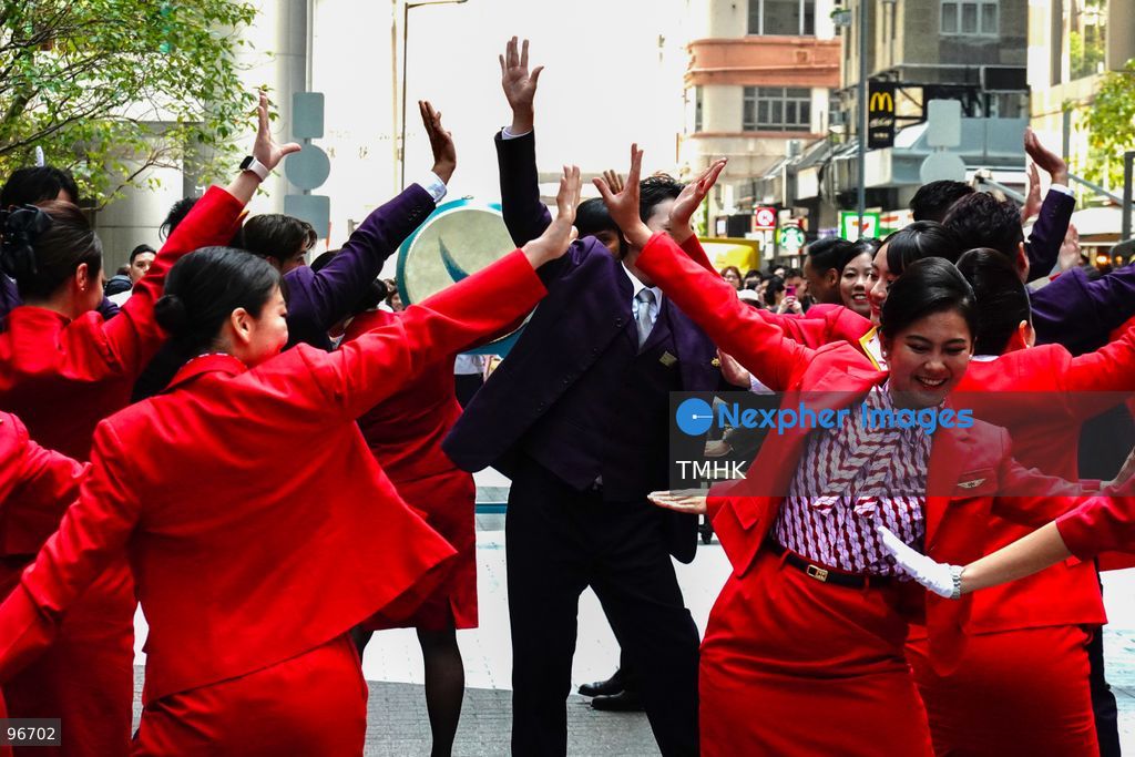 A general view shows cabin crew and ground staff wearing vintage and current uniforms performing alongside professional dancers during Cathay Pacific's 80th anniversary dance performance at Taikoo Place in Quarry Bay on September 24, 2026 in Hong Kong. Choreographed by the Hong Kong Dance Company, the flash mob-style showcase celebrated the airline's eight decades of journey alongside the city. (Photo by Zulu Lo/TMHK via Nexpher Images)
