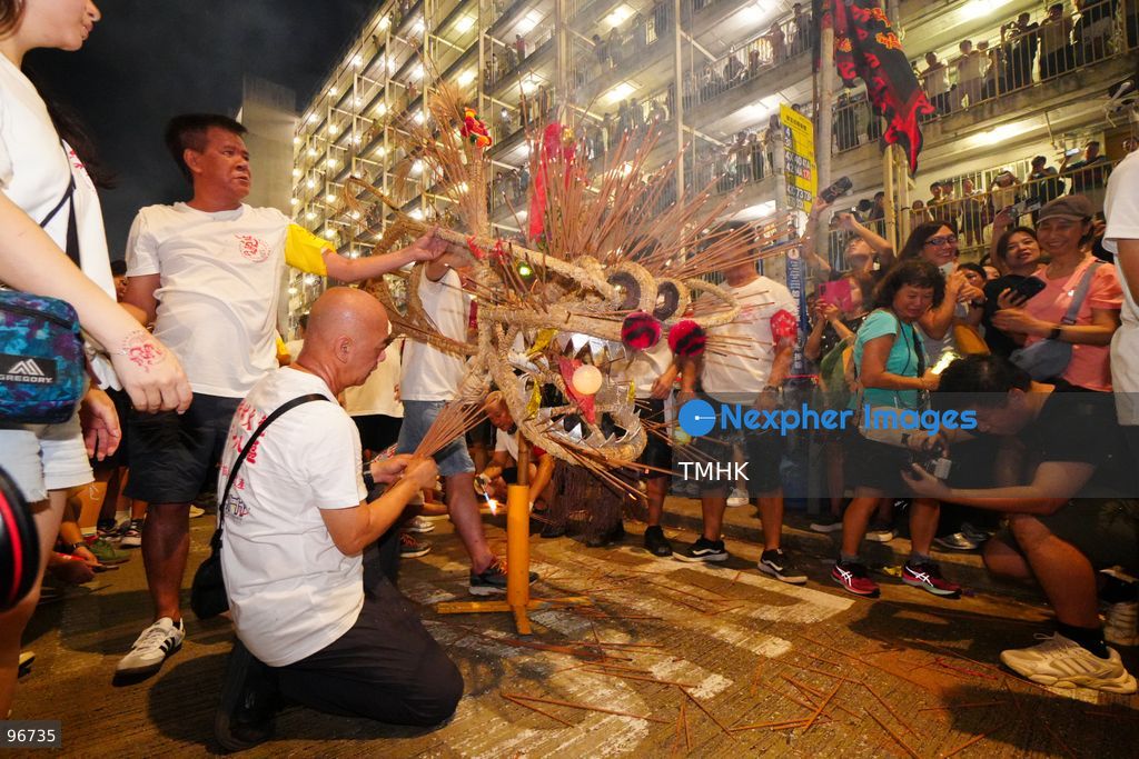 The incense-laden fire dragon weaves through public corridors and plazas of Wah Fu Estate on September 25, 2026 in Hong Kong, surrounded by dense crowds of neighbourhood residents cheering from walkways and balconies ahead of the estate's planned redevelopment. (Photo by Zulu Lo/TMHK via Nexpher Images)