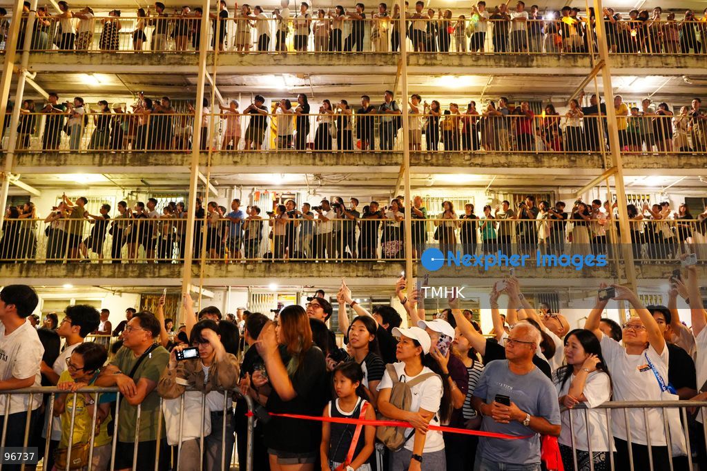 The incense-laden fire dragon weaves through public corridors and plazas of Wah Fu Estate on September 25, 2026 in Hong Kong, surrounded by dense crowds of neighbourhood residents cheering from walkways and balconies ahead of the estate's planned redevelopment. (Photo by Zulu Lo/TMHK via Nexpher Images)