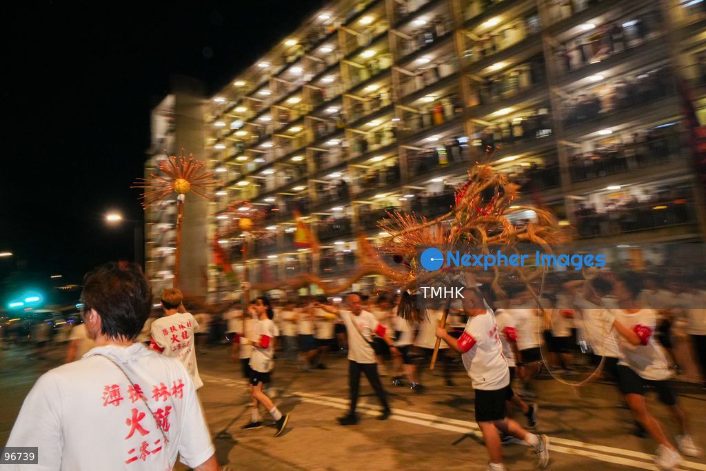 The incense-laden fire dragon weaves through public corridors and plazas of Wah Fu Estate on September 25, 2026 in Hong Kong, surrounded by dense crowds of neighbourhood residents cheering from walkways and balconies ahead of the estate's planned redevelopment. (Photo by Zulu Lo/TMHK via Nexpher Images)
