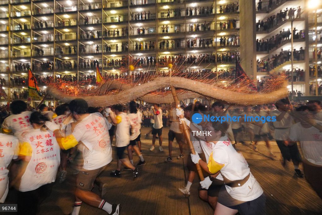 The incense-laden fire dragon weaves through public corridors and plazas of Wah Fu Estate on September 25, 2026 in Hong Kong, surrounded by dense crowds of neighbourhood residents cheering from walkways and balconies ahead of the estate's planned redevelopment. (Photo by Zulu Lo/TMHK via Nexpher Images)