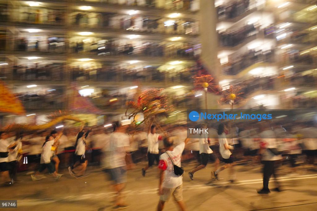 The incense-laden fire dragon weaves through public corridors and plazas of Wah Fu Estate on September 25, 2026 in Hong Kong, surrounded by dense crowds of neighbourhood residents cheering from walkways and balconies ahead of the estate's planned redevelopment. (Photo by Zulu Lo/TMHK via Nexpher Images)