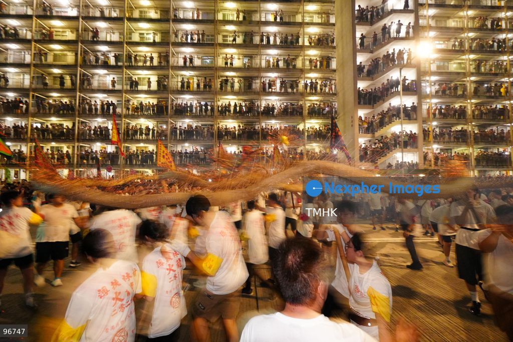 The incense-laden fire dragon weaves through public corridors and plazas of Wah Fu Estate on September 25, 2026 in Hong Kong, surrounded by dense crowds of neighbourhood residents cheering from walkways and balconies ahead of the estate's planned redevelopment. (Photo by Zulu Lo/TMHK via Nexpher Images)