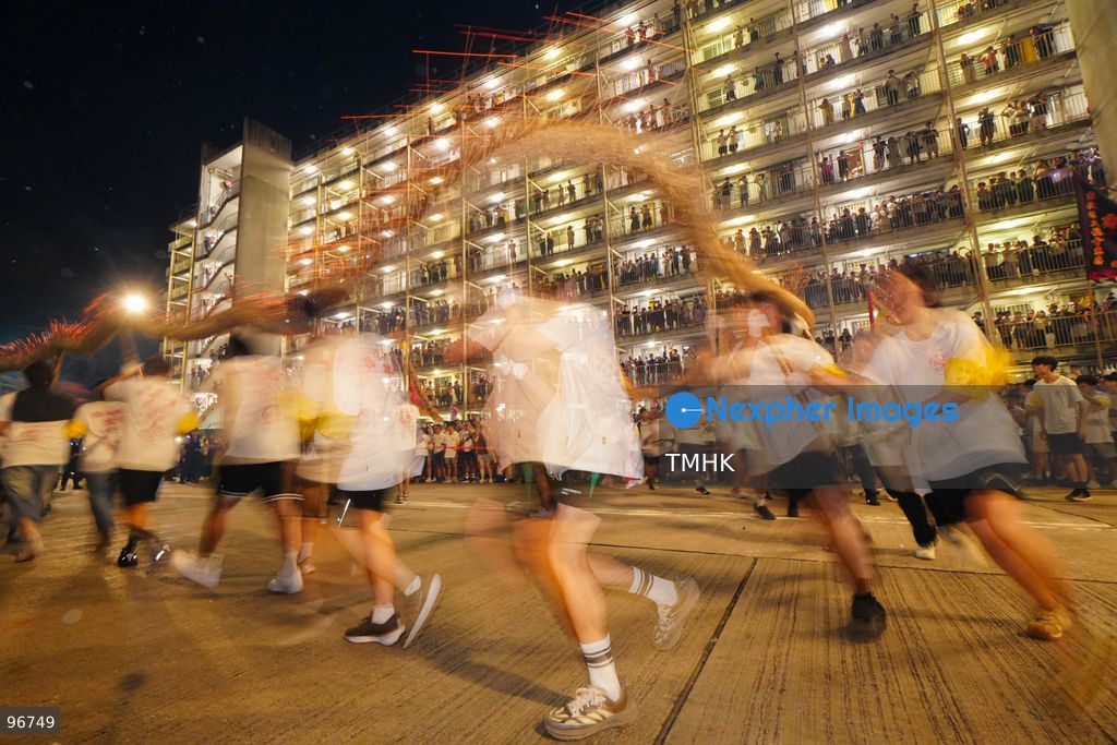 The incense-laden fire dragon weaves through public corridors and plazas of Wah Fu Estate on September 25, 2026 in Hong Kong, surrounded by dense crowds of neighbourhood residents cheering from walkways and balconies ahead of the estate's planned redevelopment. (Photo by Zulu Lo/TMHK via Nexpher Images)