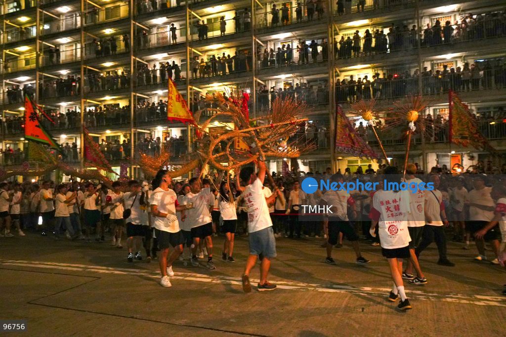 The incense-laden fire dragon weaves through public corridors and plazas of Wah Fu Estate on September 25, 2026 in Hong Kong, surrounded by dense crowds of neighbourhood residents cheering from walkways and balconies ahead of the estate's planned redevelopment. (Photo by Zulu Lo/TMHK via Nexpher Images)