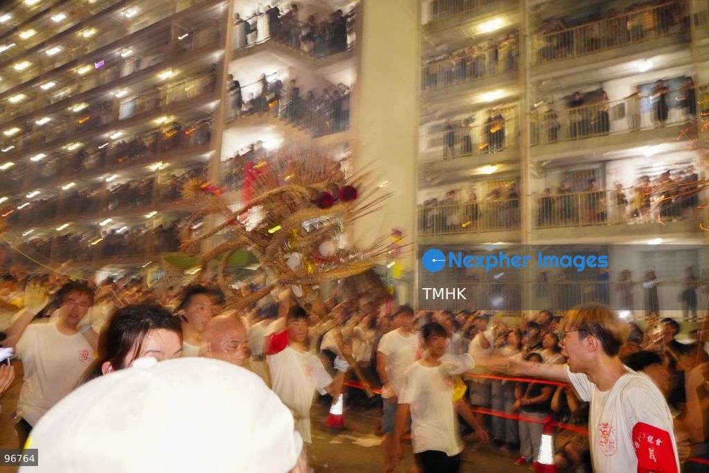 The incense-laden fire dragon weaves through public corridors and plazas of Wah Fu Estate on September 25, 2026 in Hong Kong, surrounded by dense crowds of neighbourhood residents cheering from walkways and balconies ahead of the estate's planned redevelopment. (Photo by Zulu Lo/TMHK via Nexpher Images)