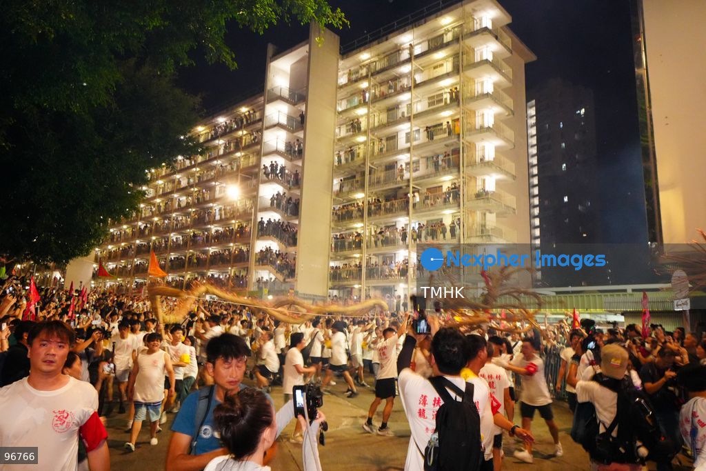 The incense-laden fire dragon weaves through public corridors and plazas of Wah Fu Estate on September 25, 2026 in Hong Kong, surrounded by dense crowds of neighbourhood residents cheering from walkways and balconies ahead of the estate's planned redevelopment. (Photo by Zulu Lo/TMHK via Nexpher Images)
