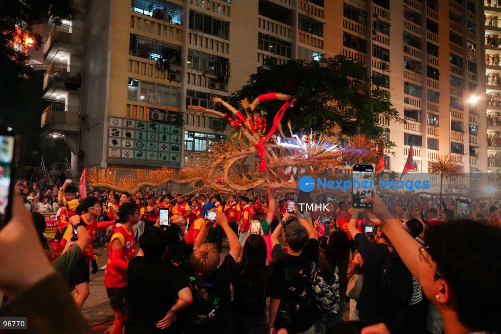 The incense-laden fire dragon weaves through public corridors and plazas of Wah Fu Estate on September 25, 2026 in Hong Kong, surrounded by dense crowds of neighbourhood residents cheering from walkways and balconies ahead of the estate's planned redevelopment. (Photo by Zulu Lo/TMHK via Nexpher Images)