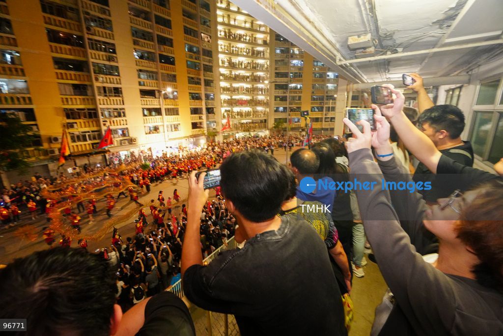 The incense-laden fire dragon weaves through public corridors and plazas of Wah Fu Estate on September 25, 2026 in Hong Kong, surrounded by dense crowds of neighbourhood residents cheering from walkways and balconies ahead of the estate's planned redevelopment. (Photo by Zulu Lo/TMHK via Nexpher Images)