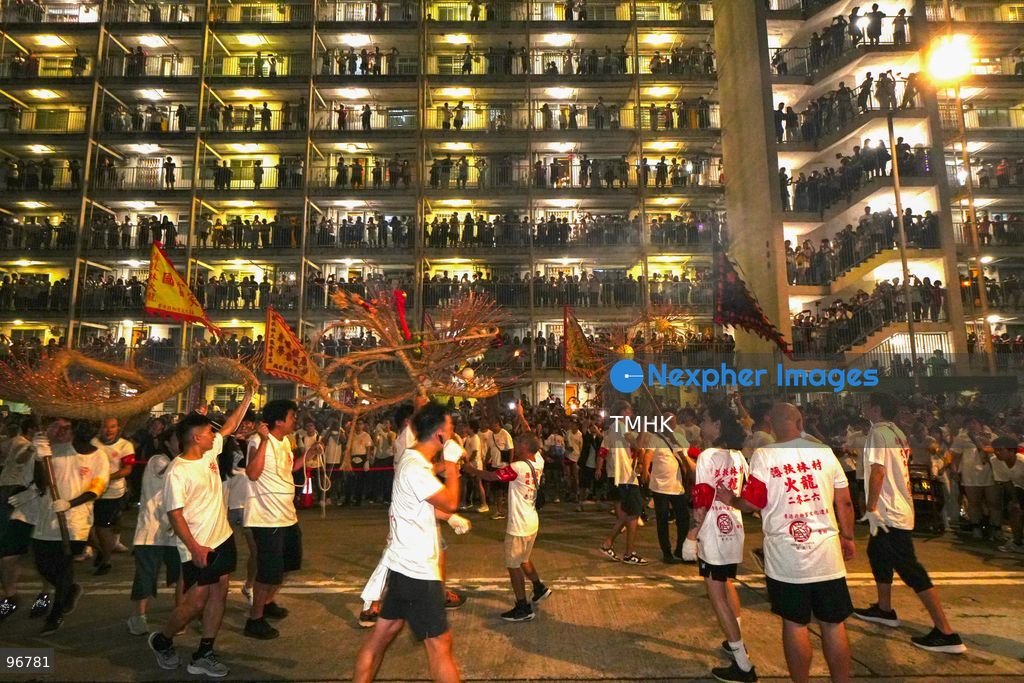 The incense-laden fire dragon weaves through public corridors and plazas of Wah Fu Estate on September 25, 2026 in Hong Kong, surrounded by dense crowds of neighbourhood residents cheering from walkways and balconies ahead of the estate's planned redevelopment. (Photo by Zulu Lo/TMHK via Nexpher Images)